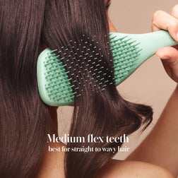Model styling hair with the Tangle Teezer Complete Carebrush in Glistening Jade