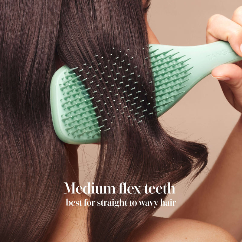 Model styling hair with the Tangle Teezer Complete Carebrush in Glistening Jade